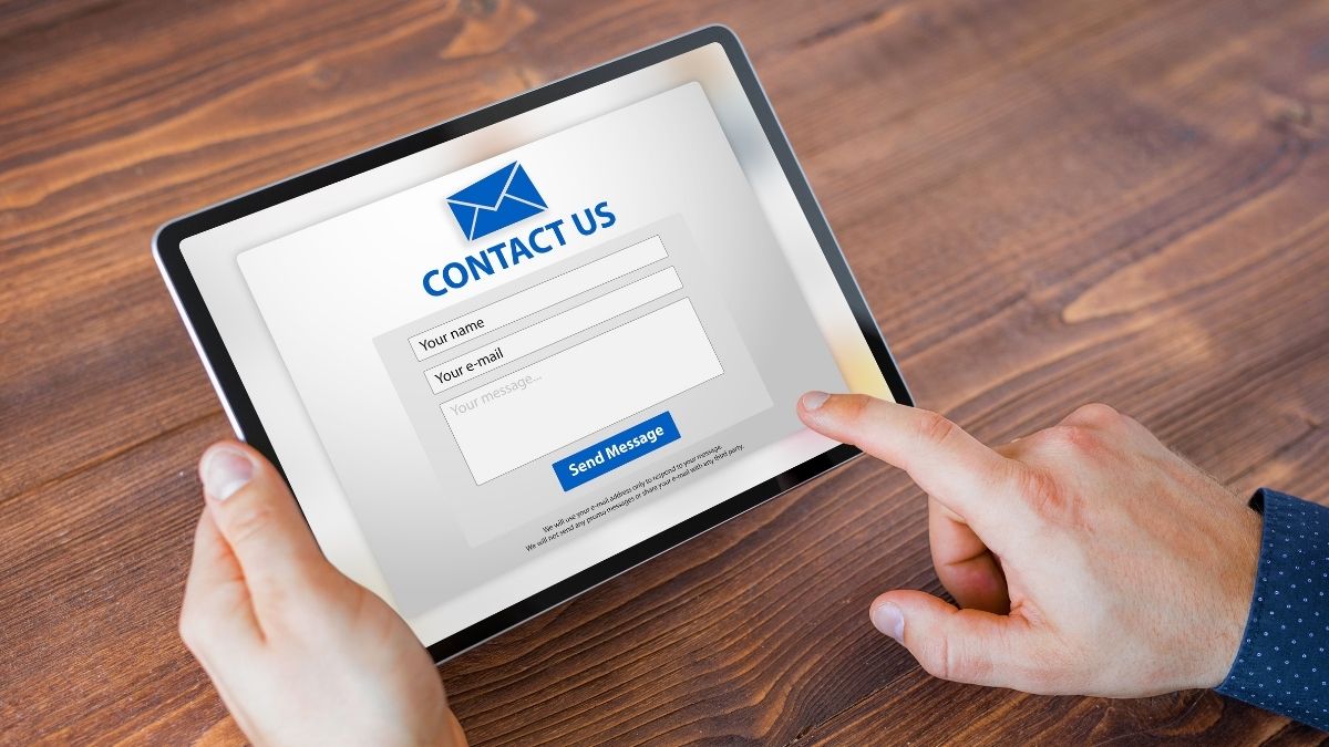 hand using tablet to fill out a contact form on a website